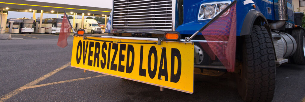 sign on truck numberplate saying oversized load